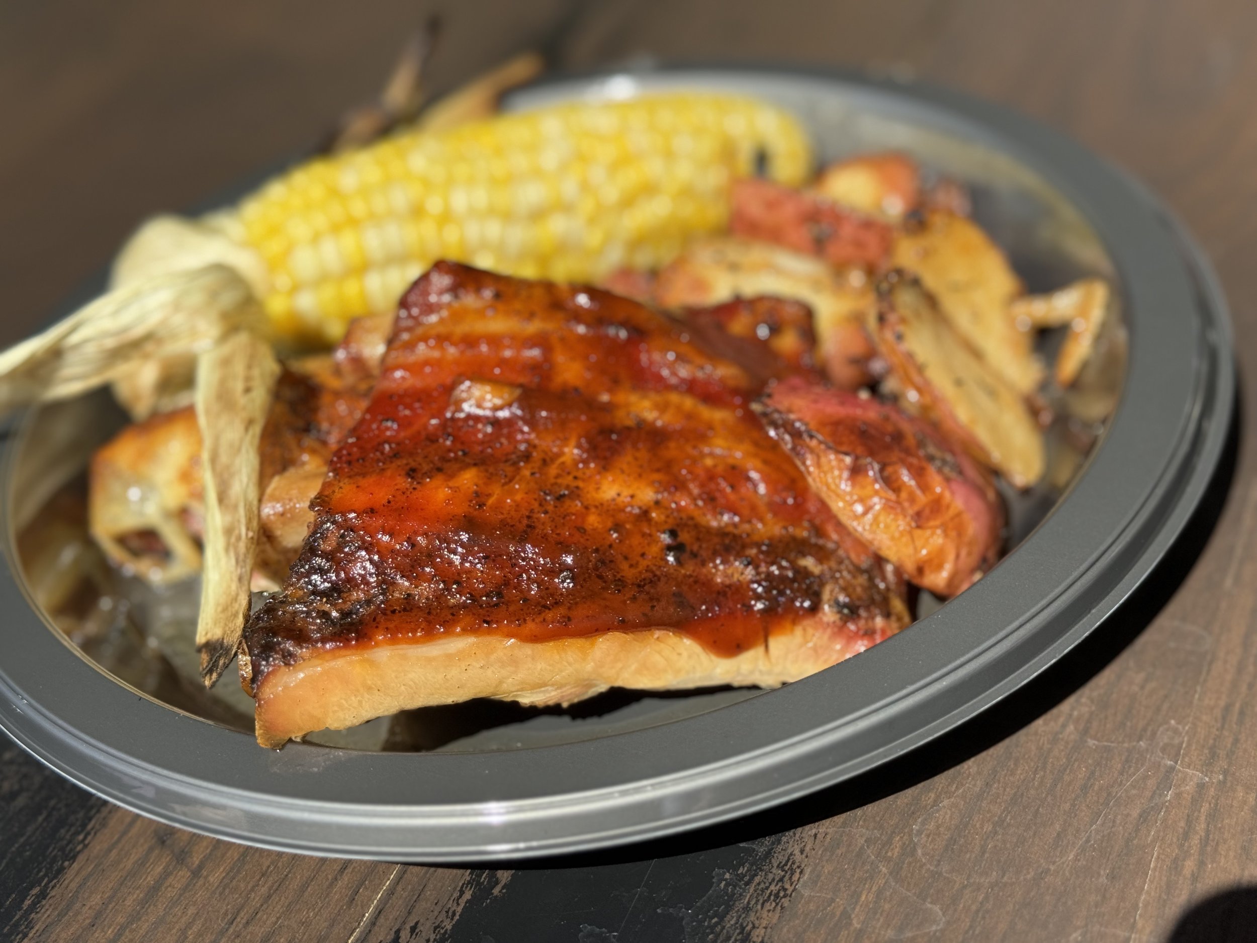 Grilled BBQ ribs sandwich with corn on cruise ship plate