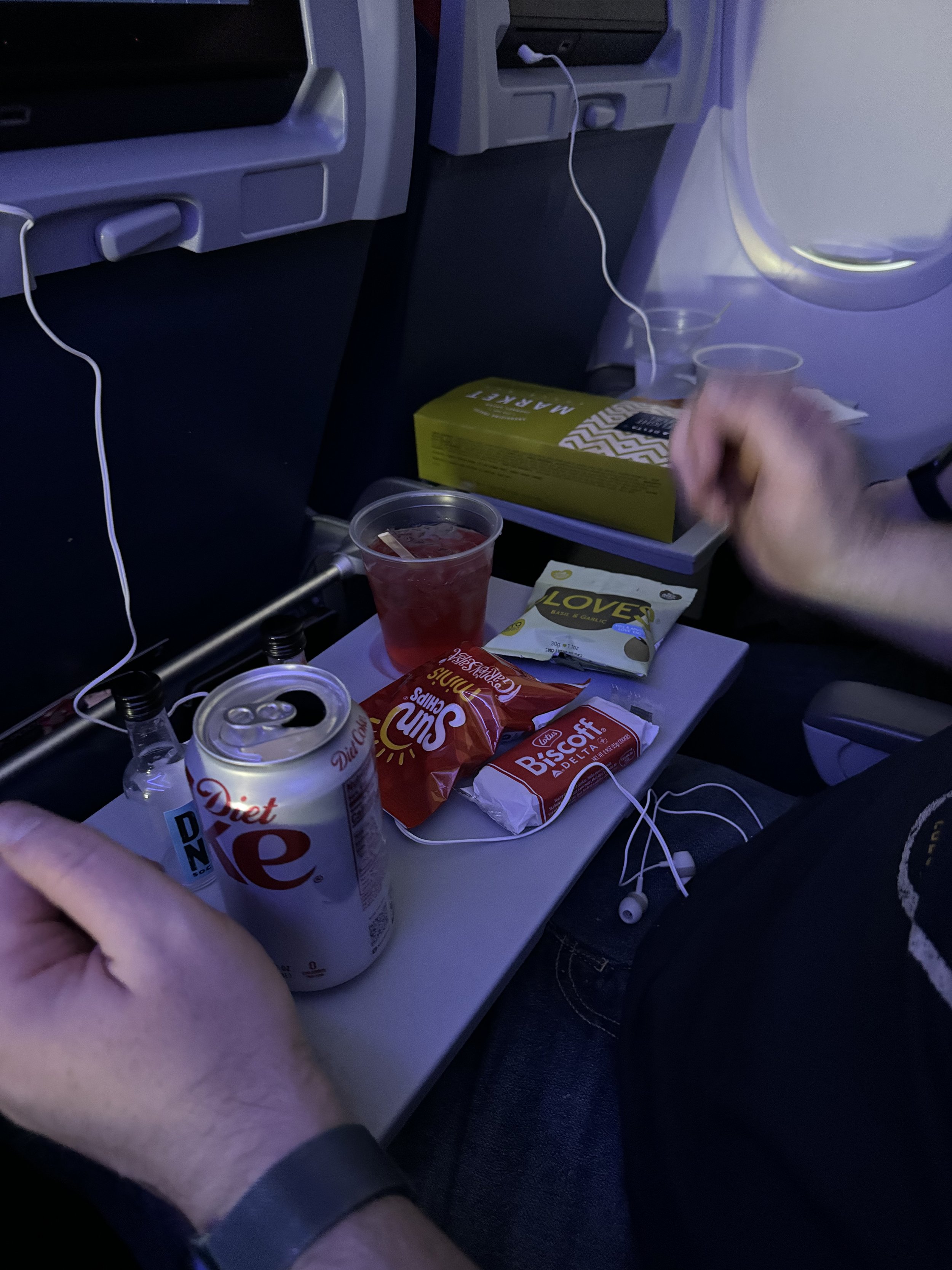 Airplane meal tray with Diet Coke and snacks during flight