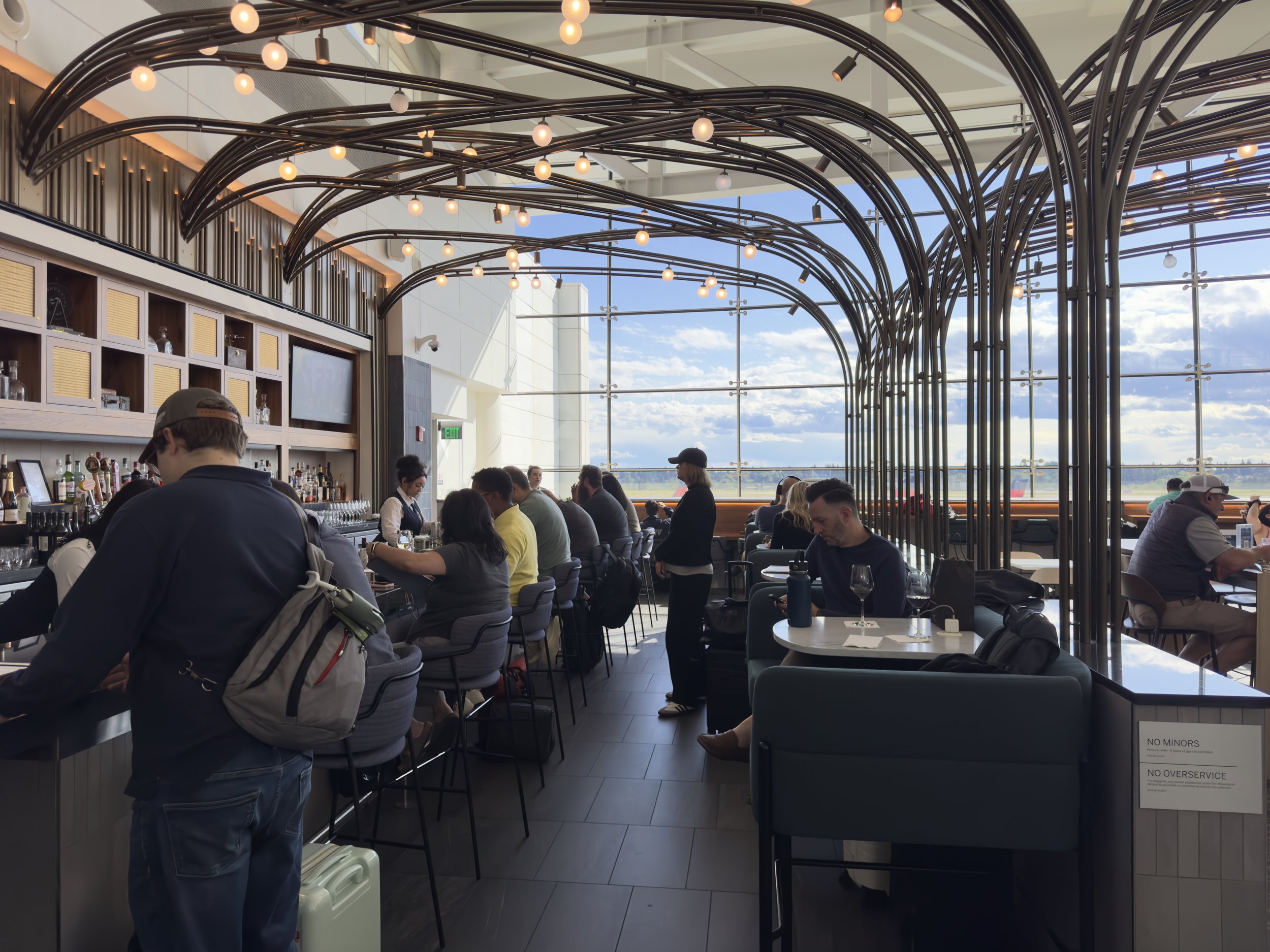 Modern airport or cruise ship lounge with ocean views and diners
