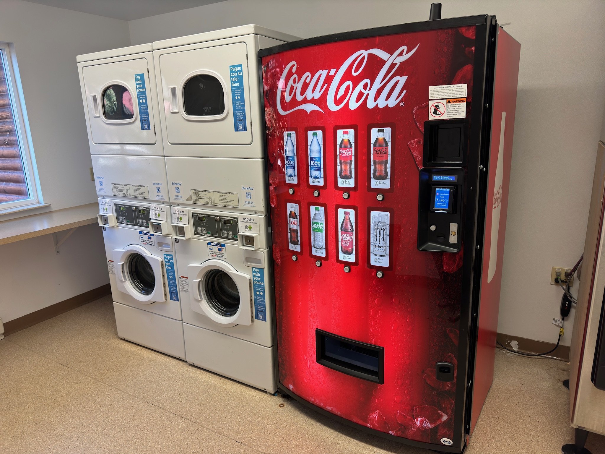 Laundry room with washing machines and Coca-Cola vending machine
