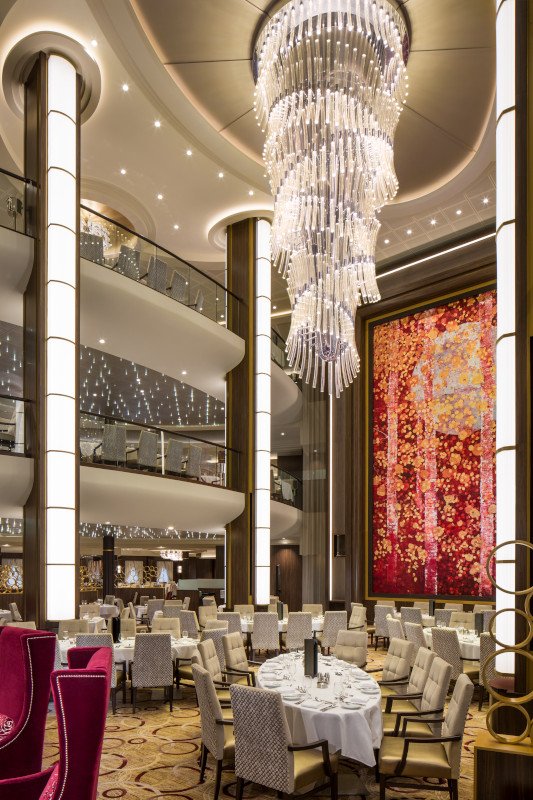 Elegant multi-level dining room with crystal chandelier and red artwork