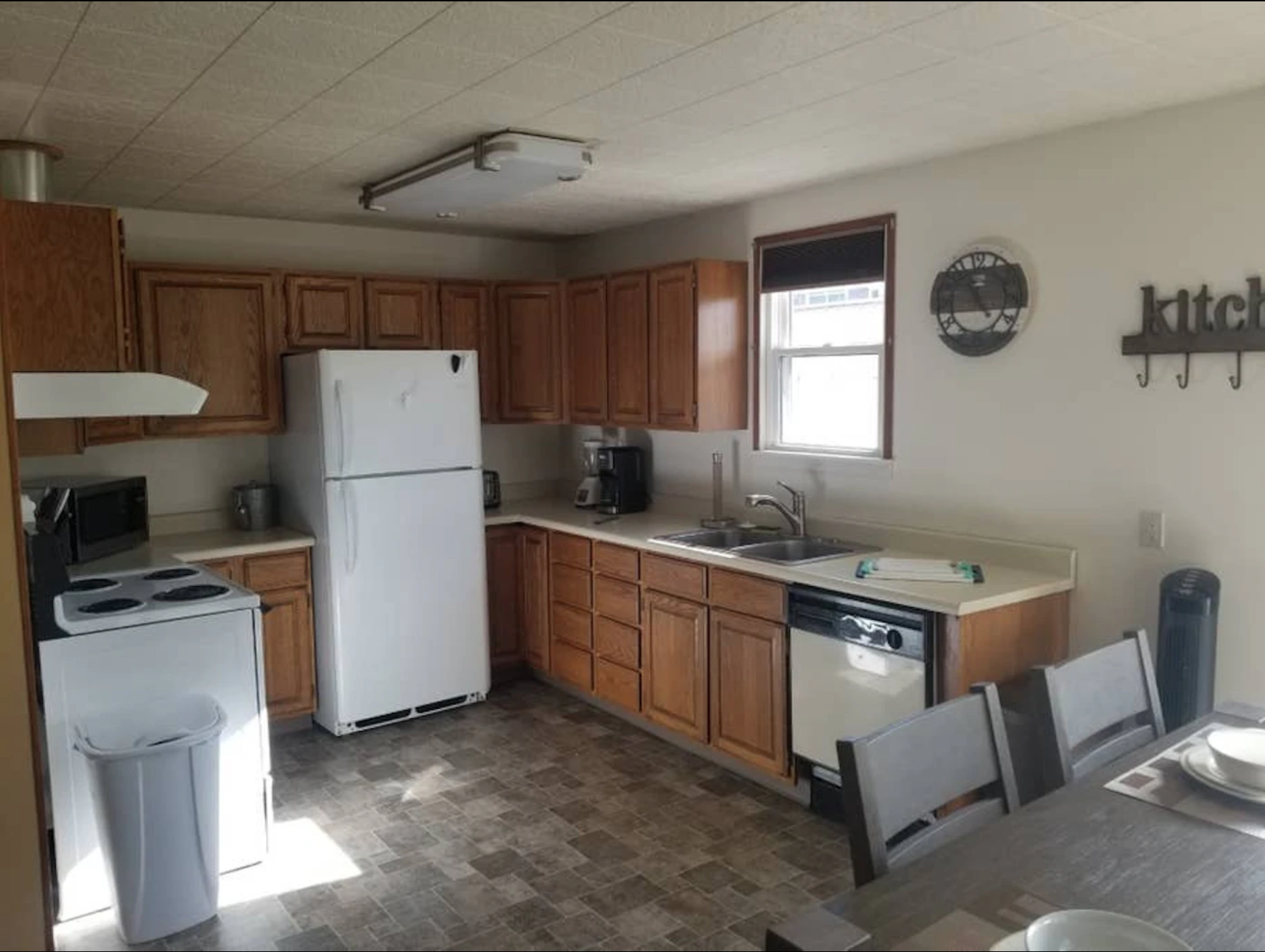 Kitchen cabin with wood cabinets and white appliances