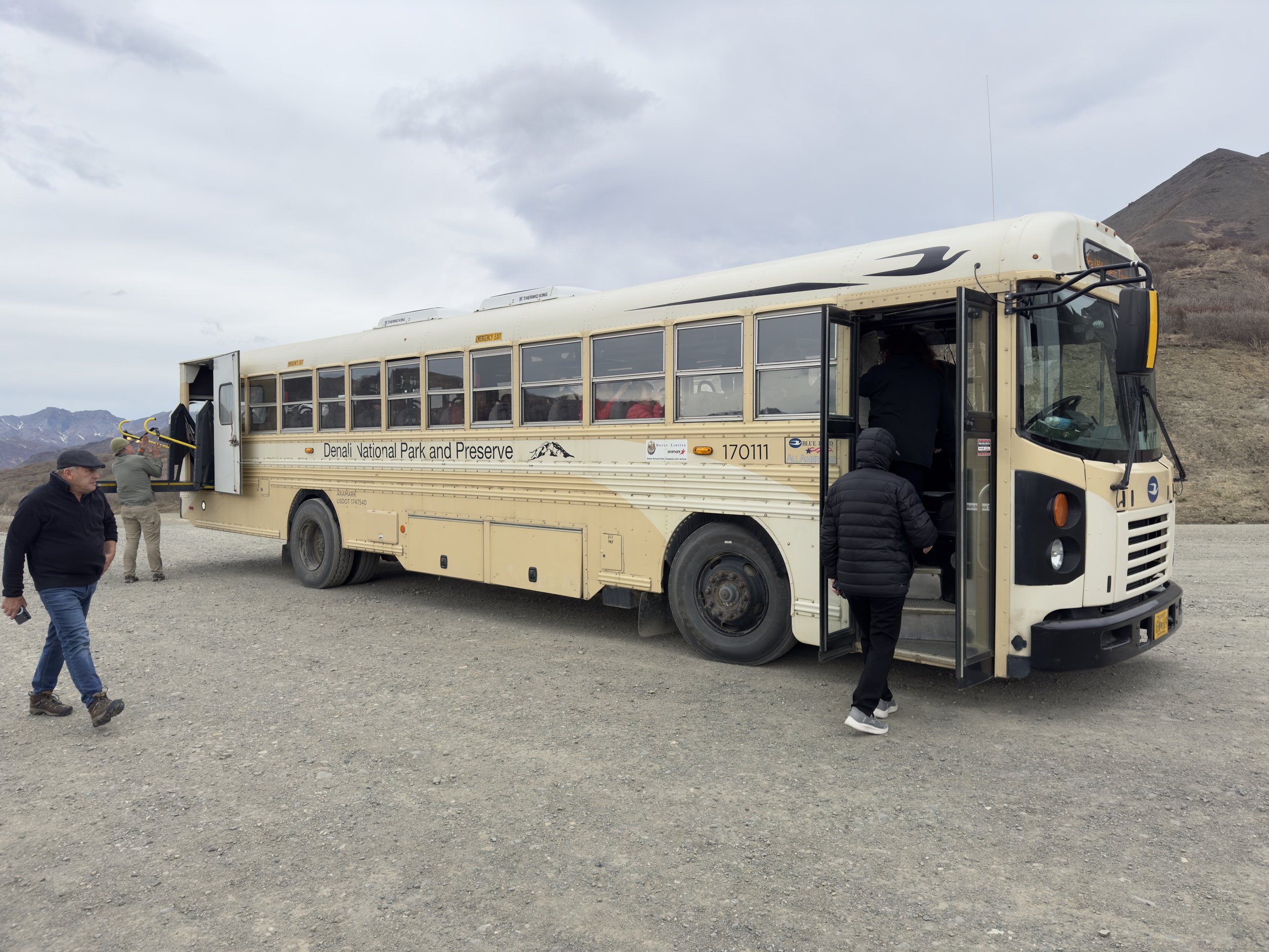 Denali National Park shuttle bus with visitors boarding for park tour