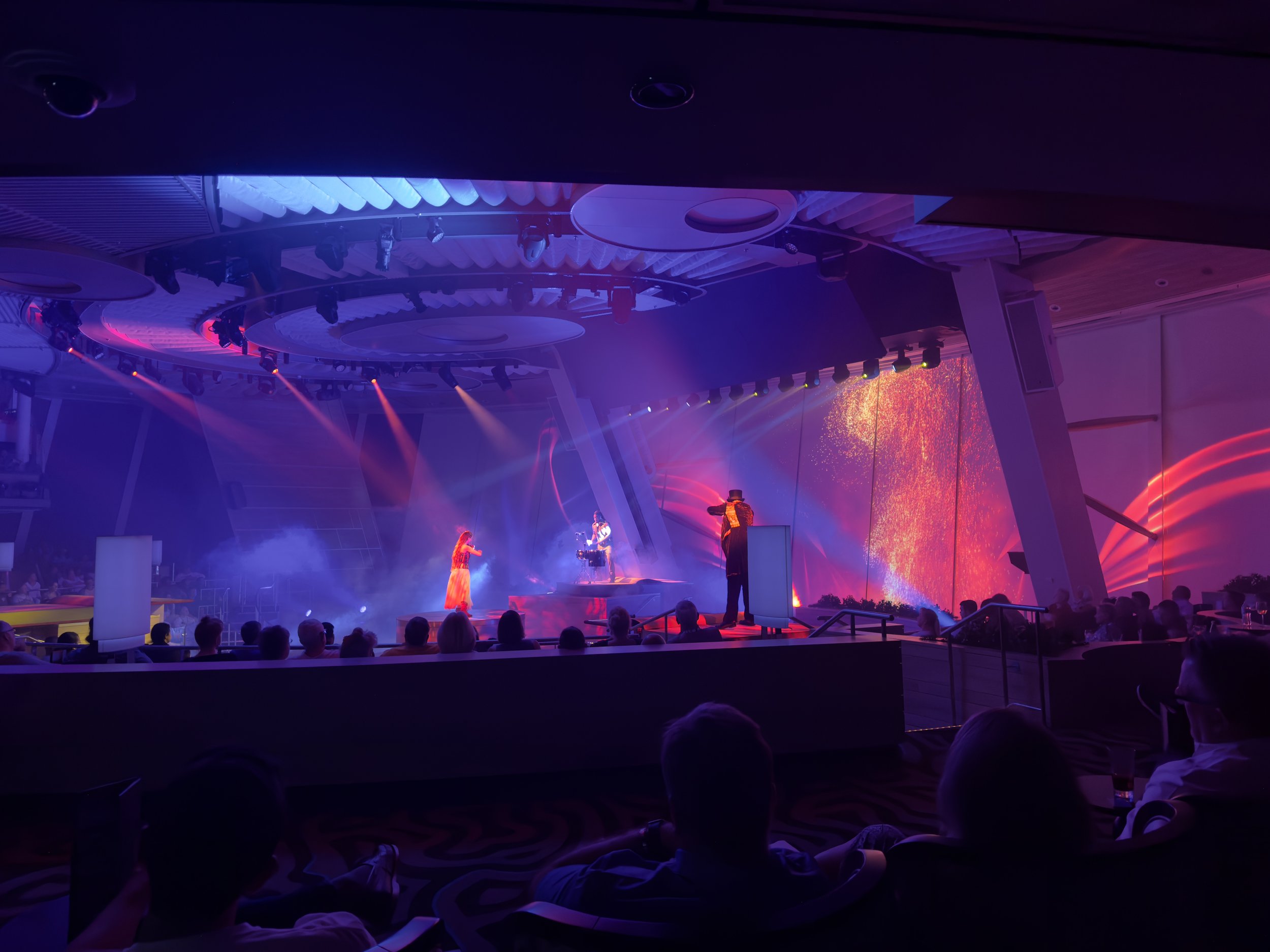 Live stage performance with red lighting on cruise ship theater