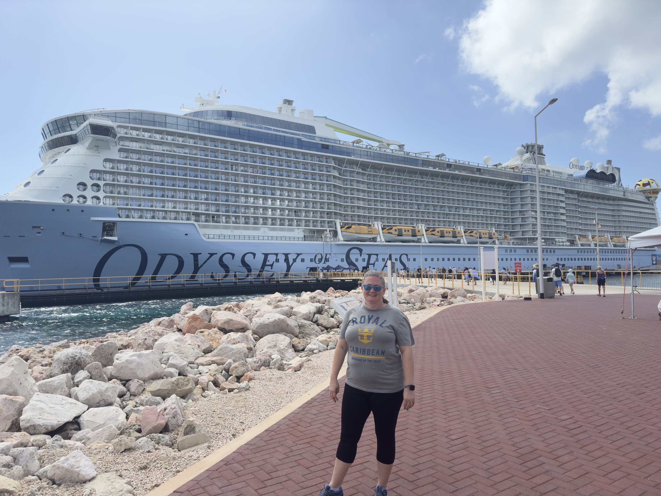 Person poses before Odyssey of the Seas cruise ship docked