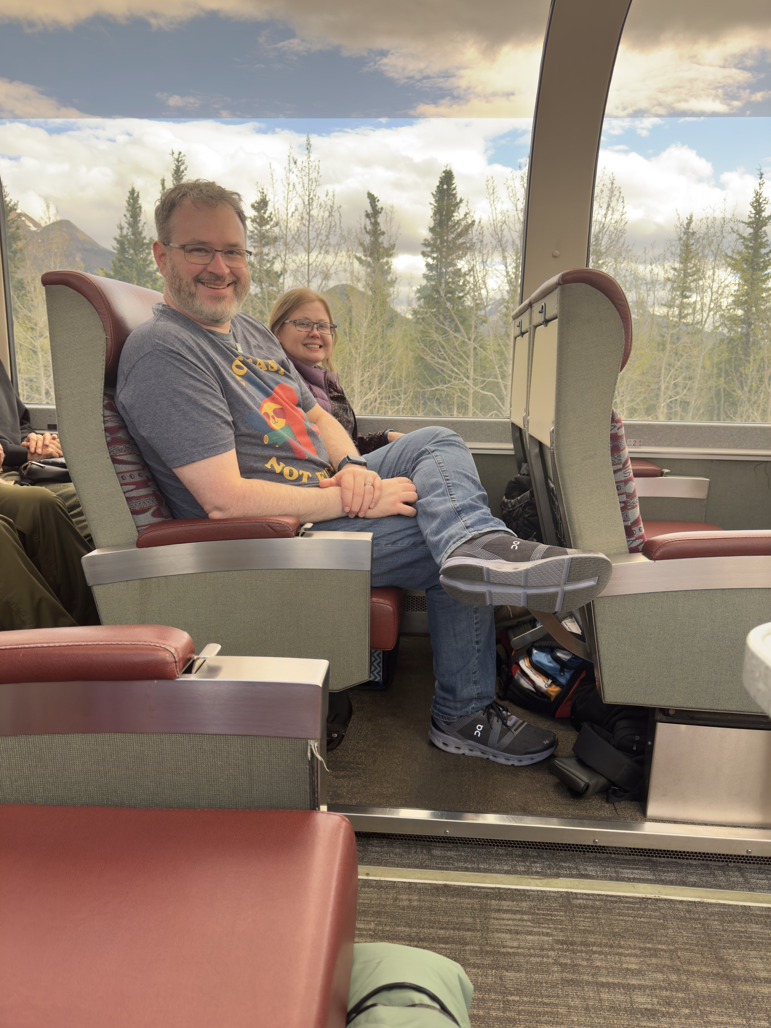 Two passengers enjoying scenic mountain views from ship interior
